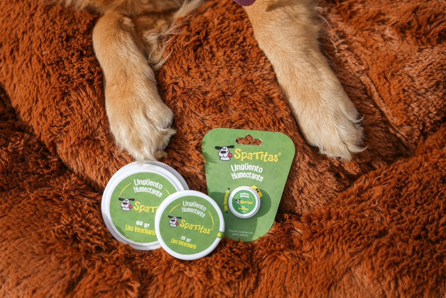 Perro descansando en su cama junto a los envases de Ungüento Humectante Spatitas